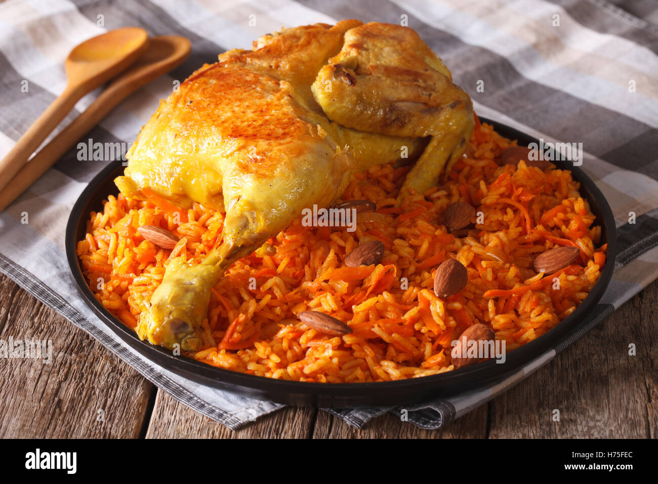 Tradizionale cibo arabo: kabsa con pollo e mandorle close-up su una piastra. Posizione orizzontale Foto Stock