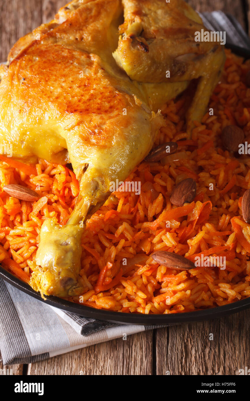 Tradizionale cibo arabo: kabsa con pollo closeup su di una piastra verticale. Foto Stock