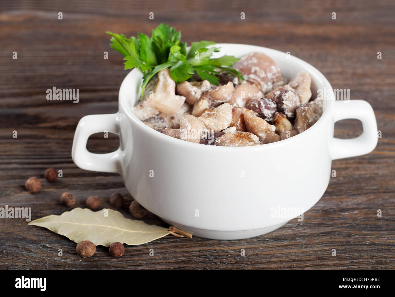 Fritti con crema di funghi di bosco in piastra bianca su di un legno marrone dello sfondo. Foto Stock
