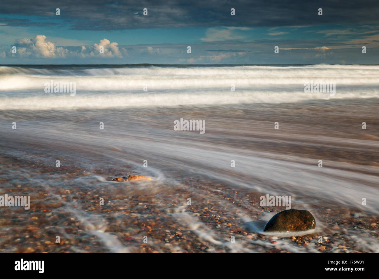 Una lunga esposizione cattura il movimento d'onda su una spiaggia Foto Stock