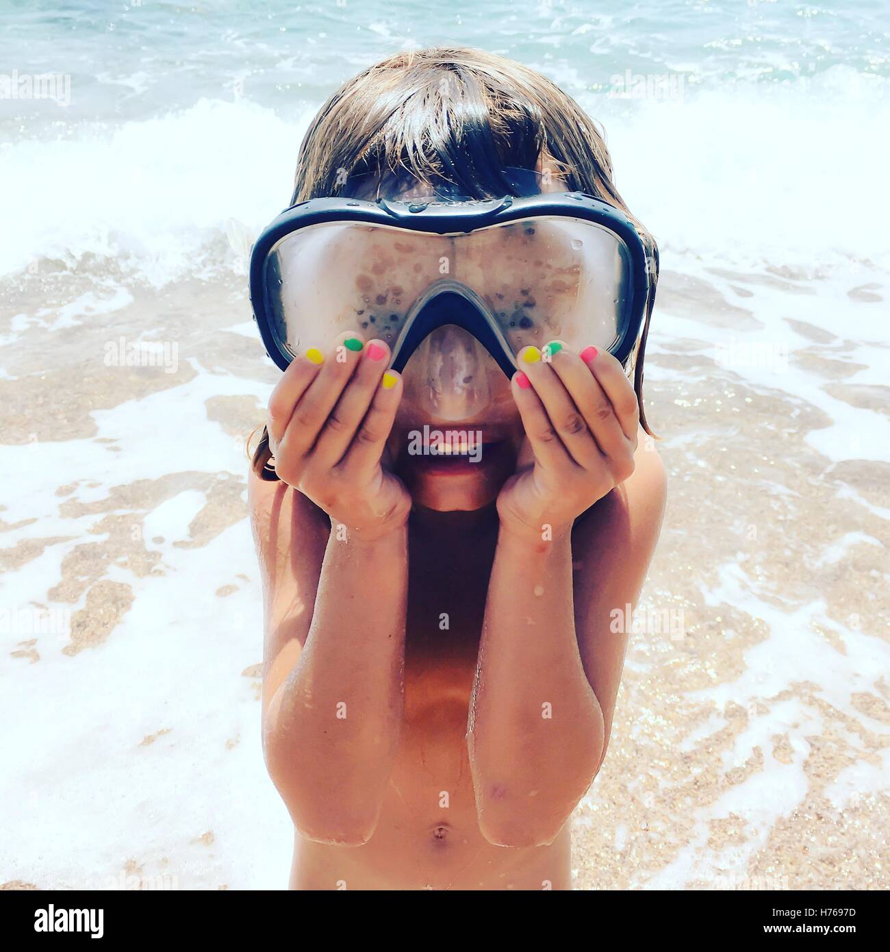 Ragazza sulla spiaggia indossando maschera snorkel Foto Stock
