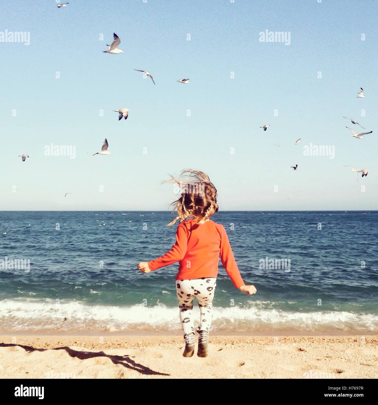 Ragazza salto sulla spiaggia Foto Stock