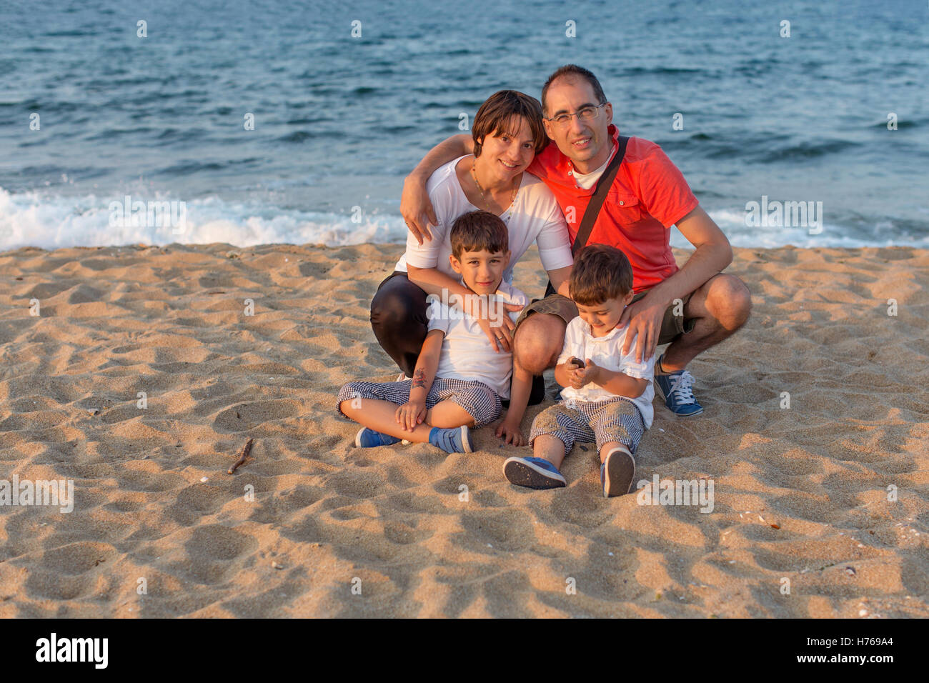 Famiglia con due bambini sulla spiaggia Foto Stock