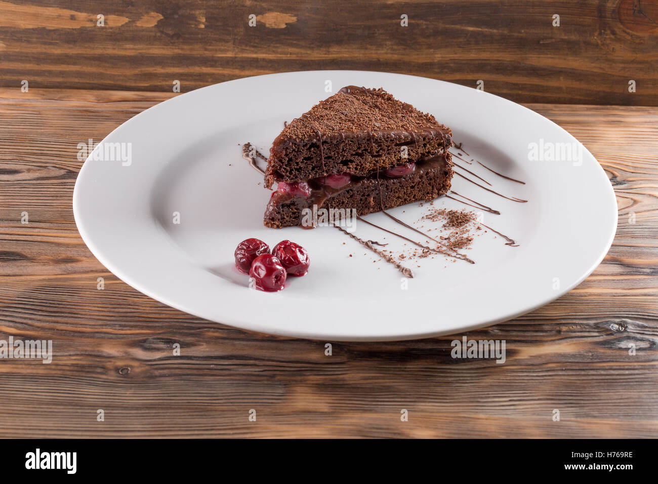 Torta al cioccolato sulla piastra sullo sfondo di legno. Foto Stock