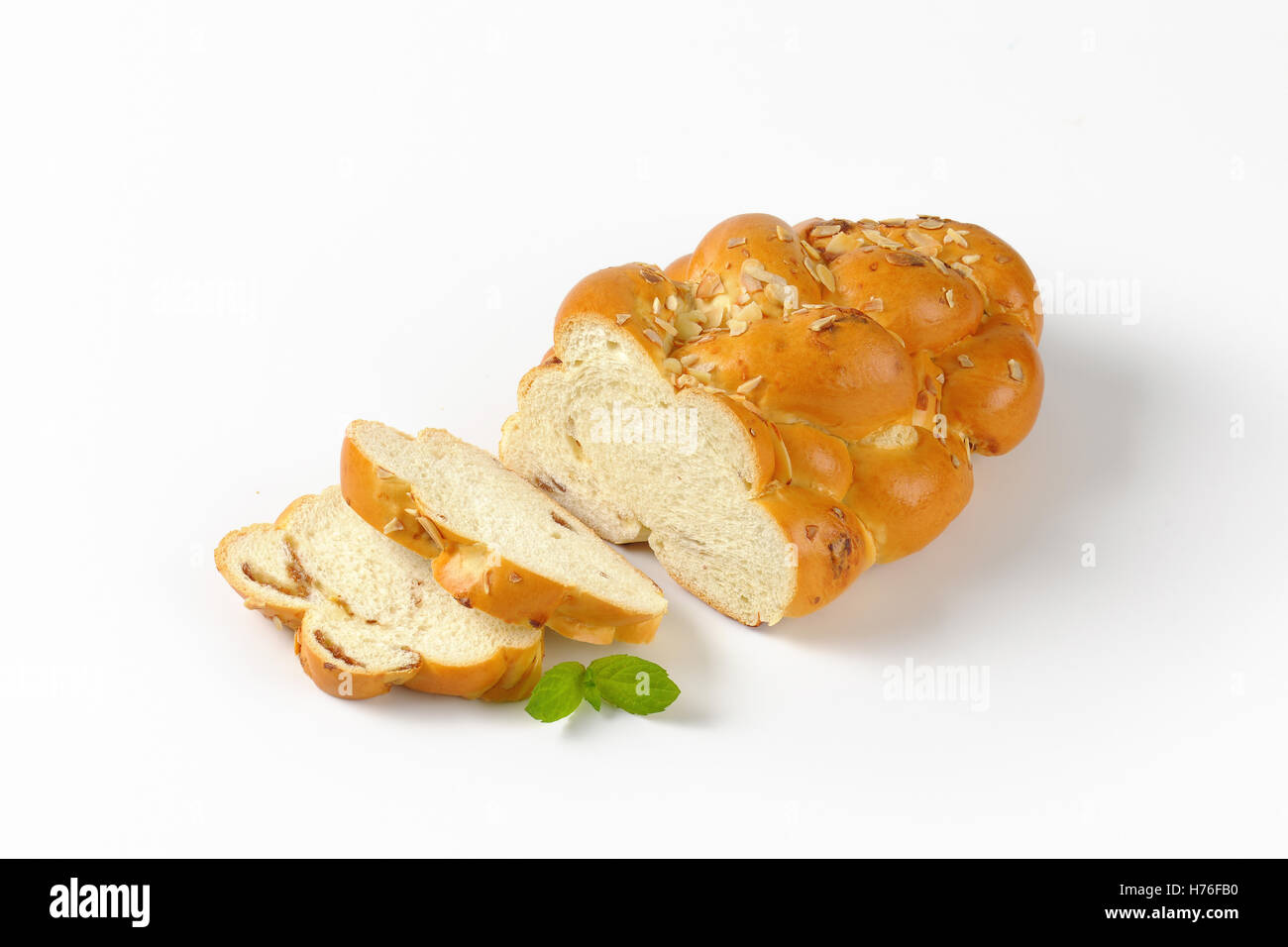 Fette di pane dolce pane intrecciato con mandorle su sfondo bianco Foto Stock