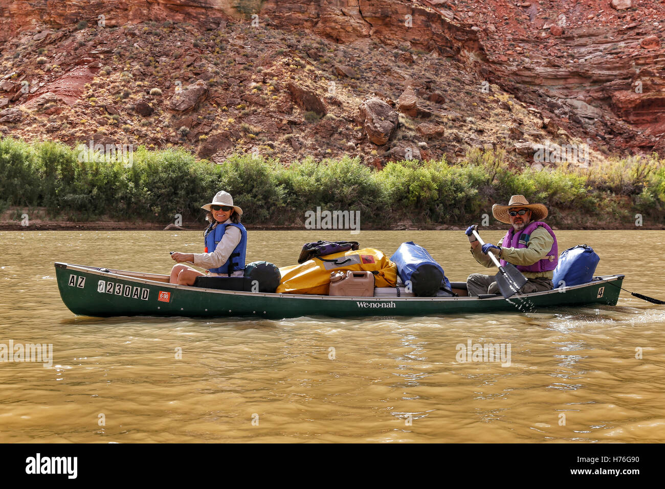 Una coppia di mezz'età le piastre una canoa lungo il fiume verde nel Parco Nazionale di Canyonlands, Utah, dopo un allagamento. Foto Stock