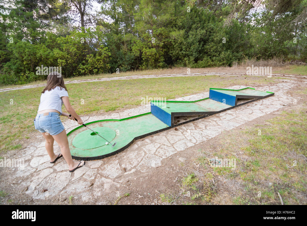 Ragazza adolescente giocando outdoor golf in miniatura in una foresta di Galilea nel nord di Israele Foto Stock