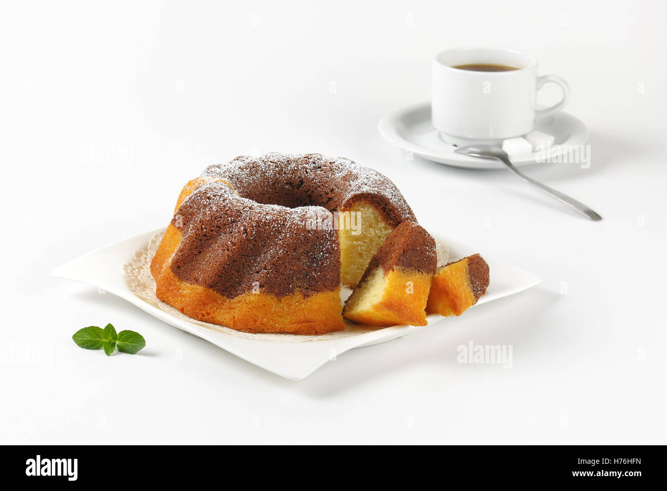 Affettato bundt di Marmo torta e tazza di caffè su sfondo bianco Foto Stock