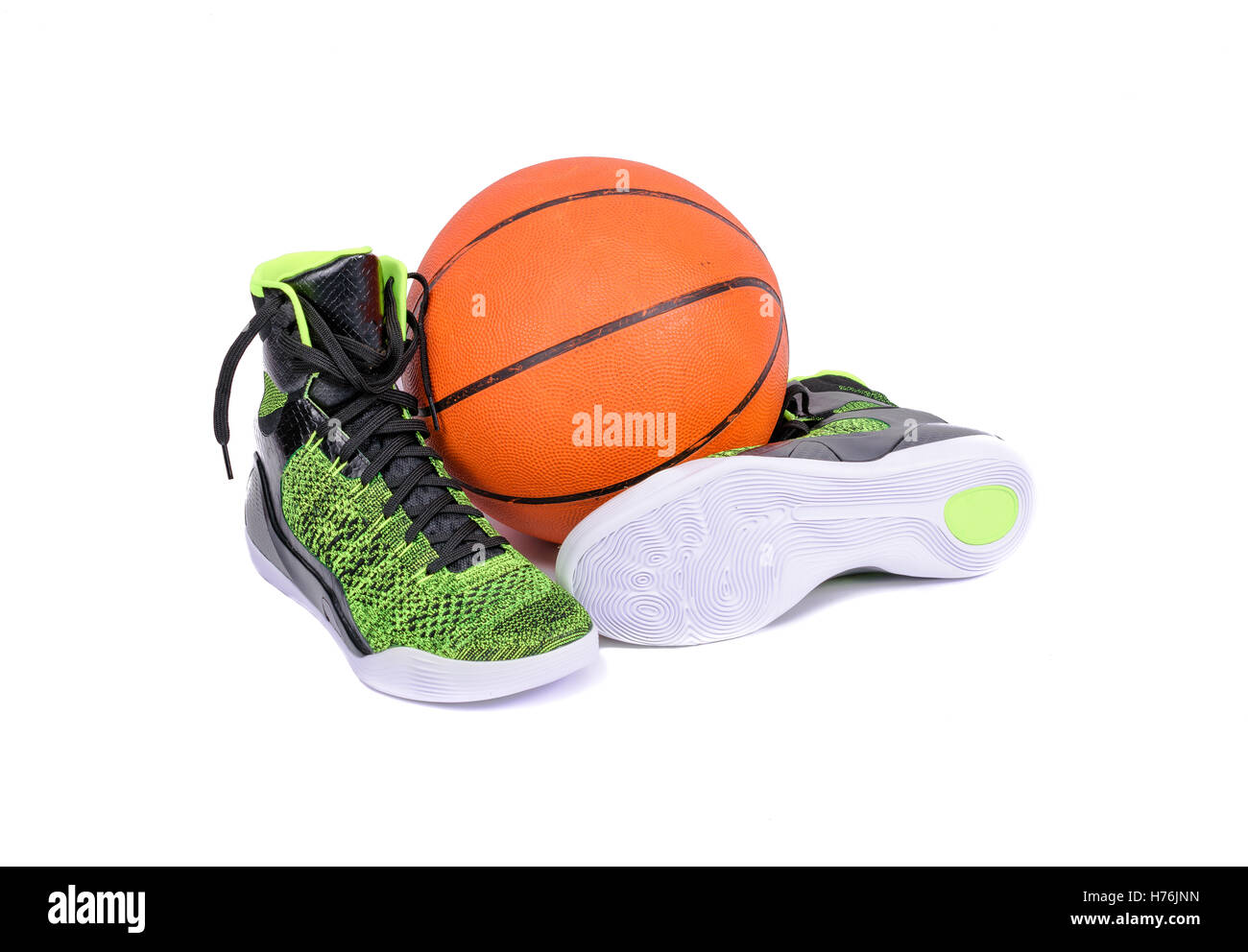 Ultra moderna di alta cima verde e nero scarpe da basket sneakers con una palla da basket, isolato su bianco Foto Stock