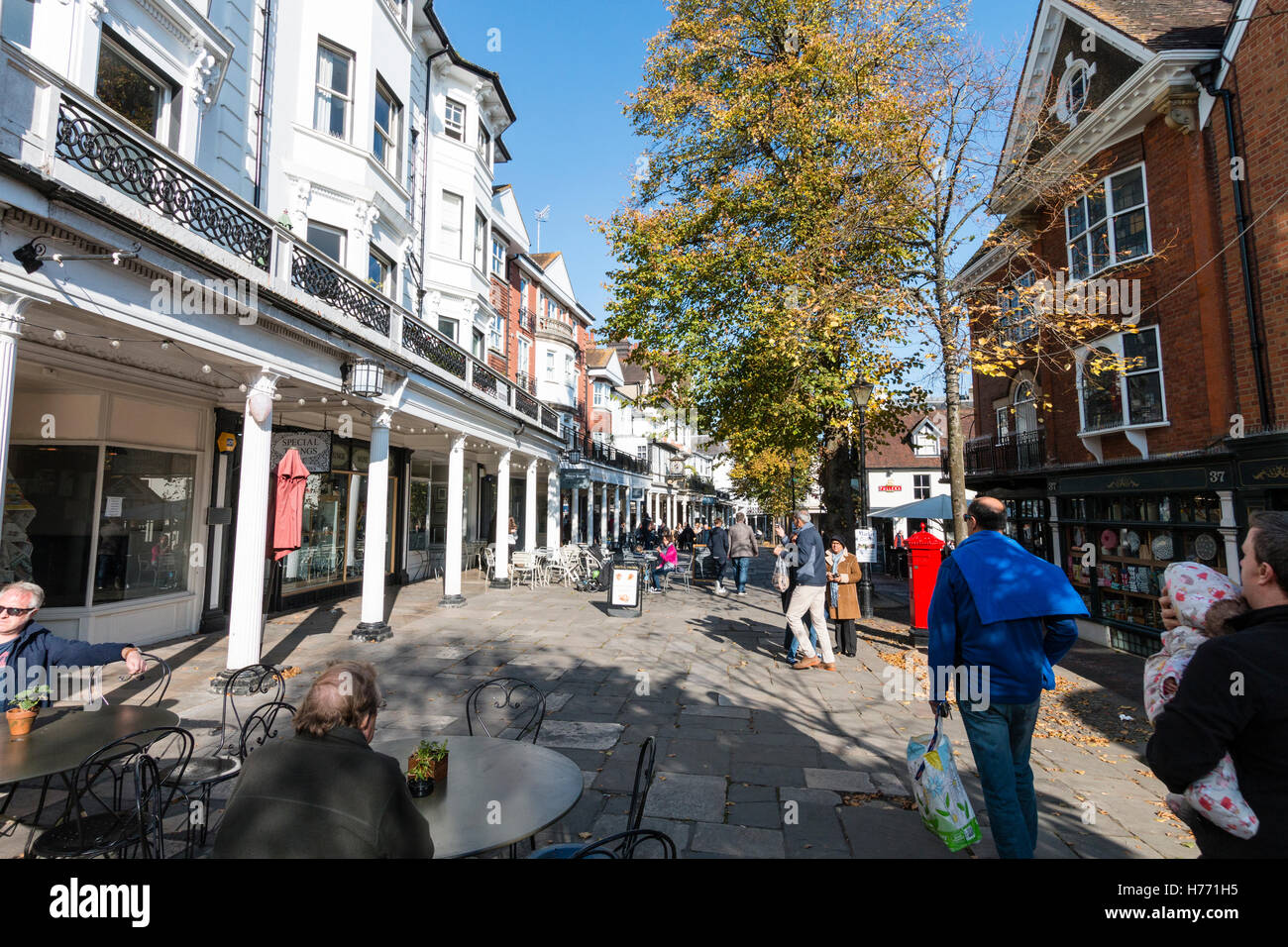 Inghilterra, Tunbridge Wells. Vista lungo la famosa Pantiles in autunno. Con facciata bianca di negozi e grandi magazzini con le persone. Sole brillante. Foto Stock