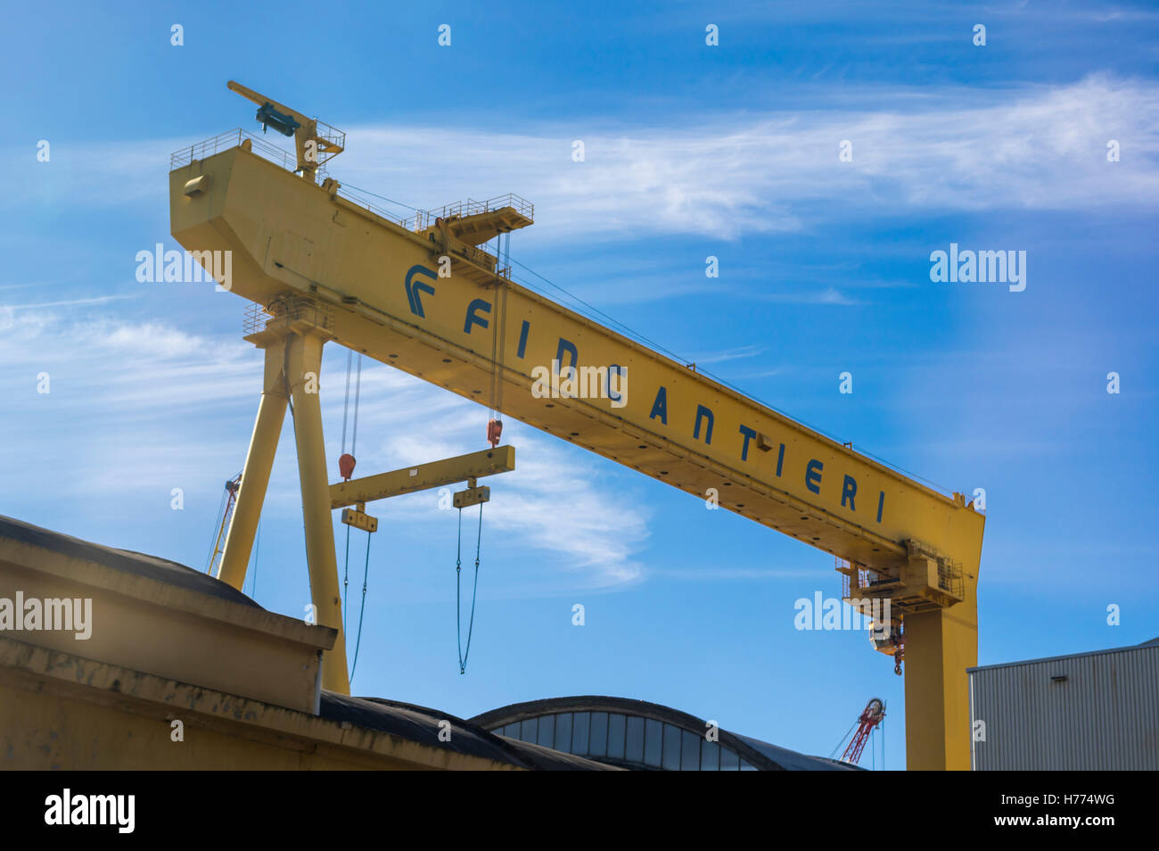 Giallo gantry crane con grande logo Fincantieri. Foto Stock