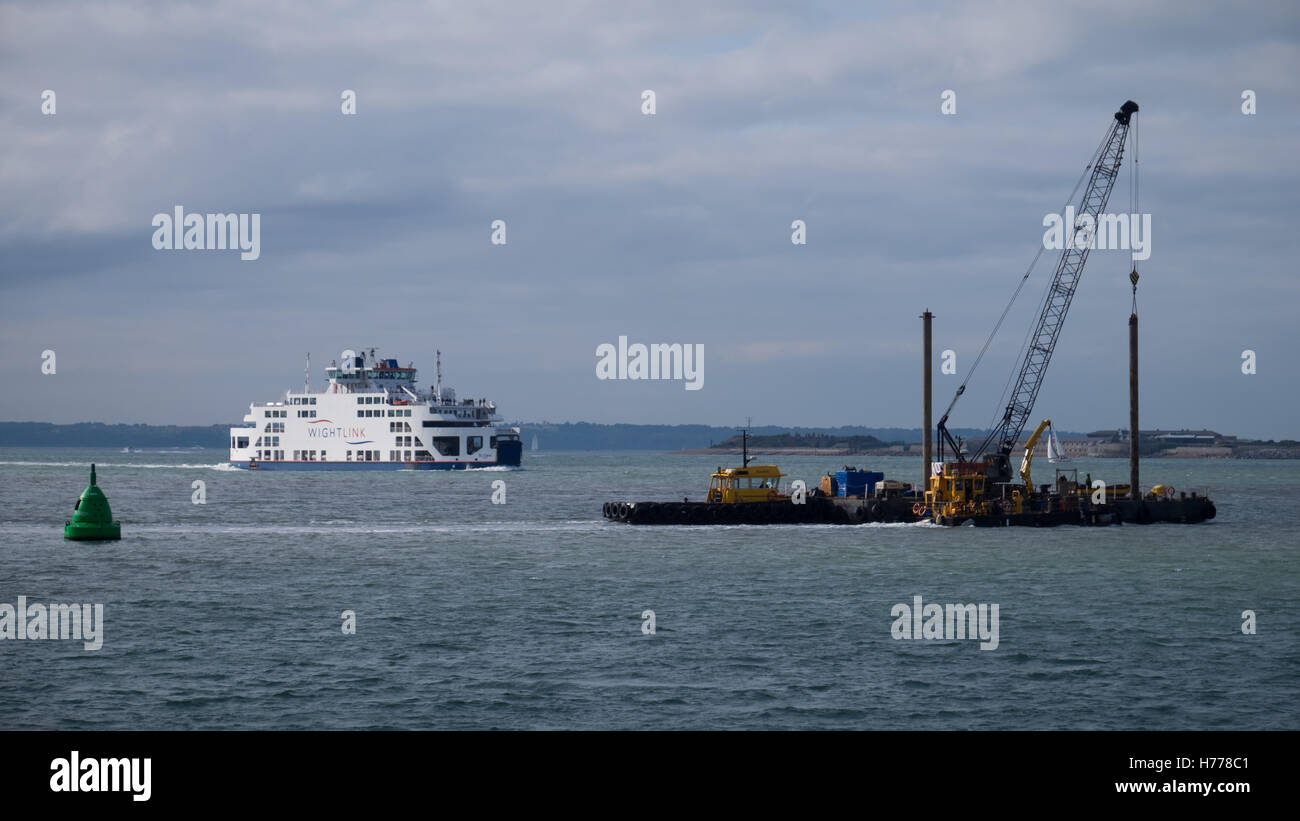 Un Wightlink traghetto per auto e una chiatta navigare il canale si avvicina al porto di Portsmouth nel Solent Foto Stock