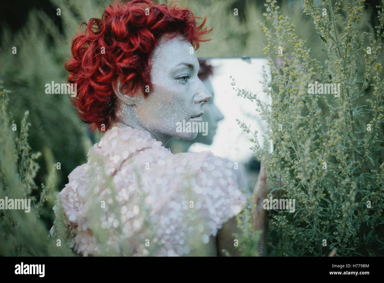 Ritratto di una donna con un dipinto di argento viso e capelli rossi Foto Stock
