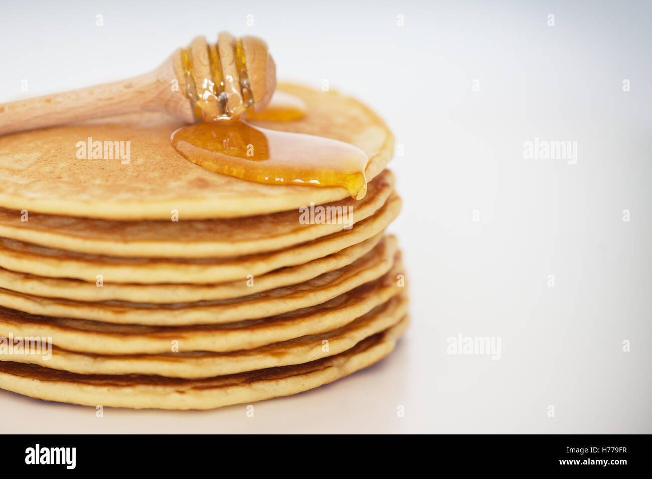 Pila di frittelle con miele Foto Stock
