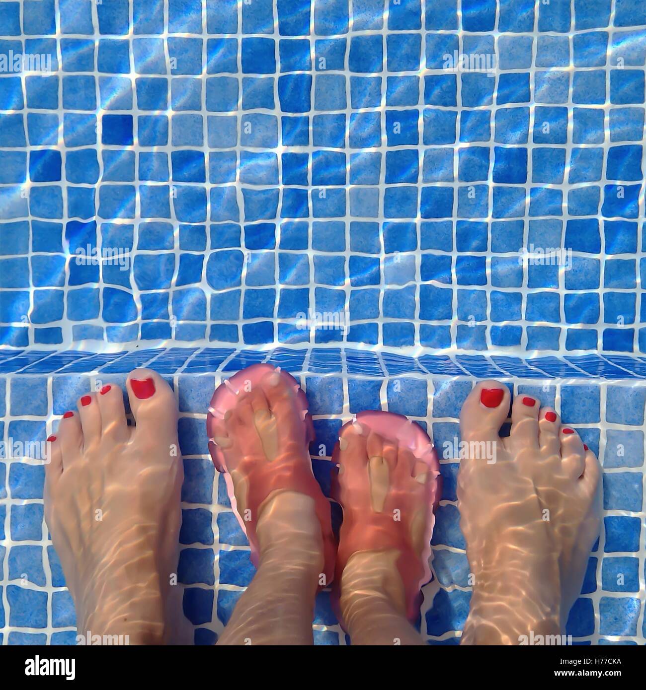 Madre in piedi in piscina con la figlia Foto Stock