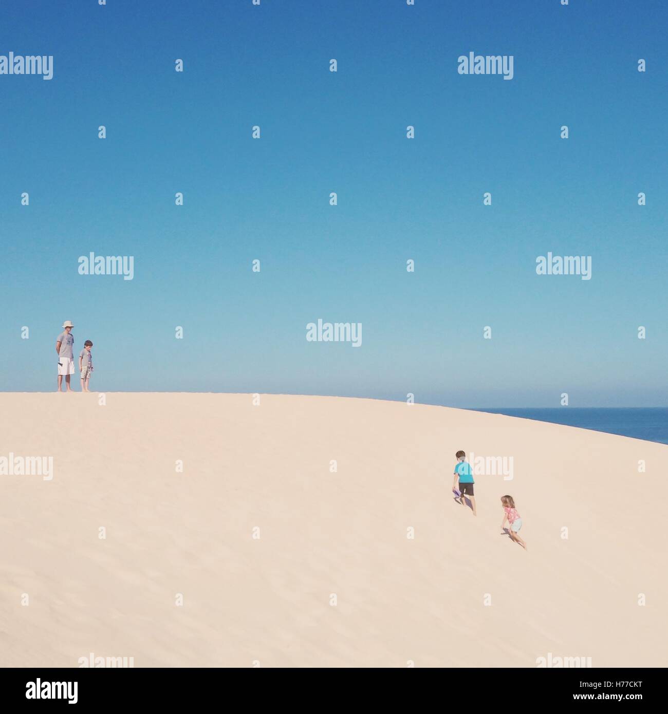 Padre di tre bambini in spiaggia Foto Stock
