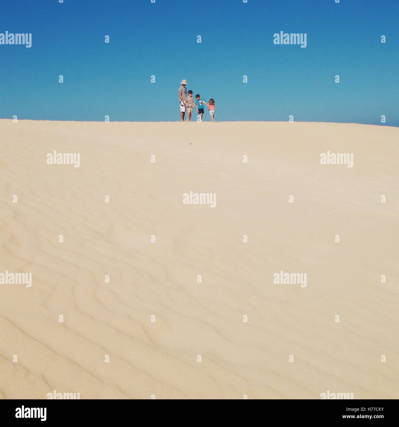 Padre di tre bambini in spiaggia Foto Stock