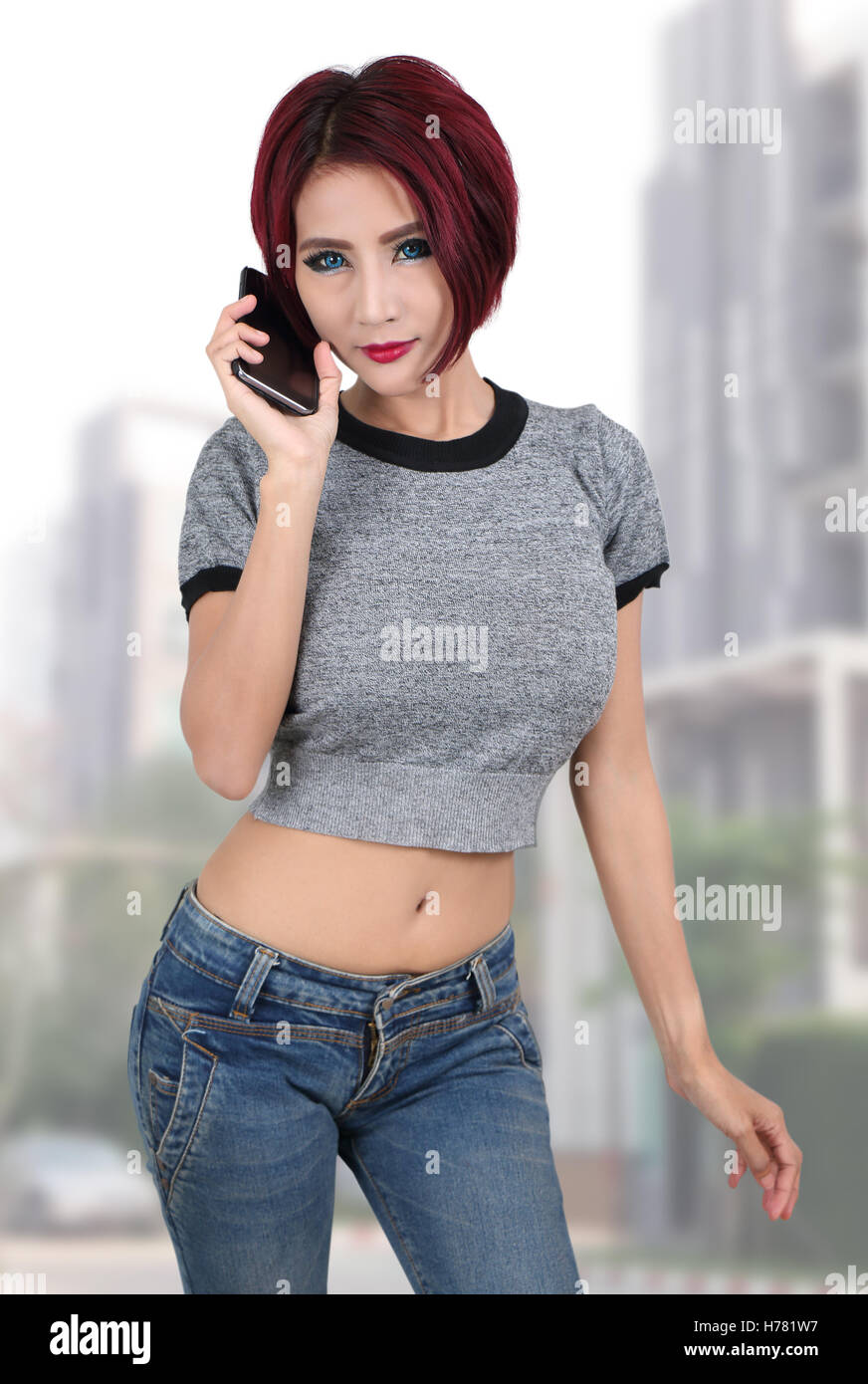 Bella giovane donna asiatica azienda smart phone Foto Stock
