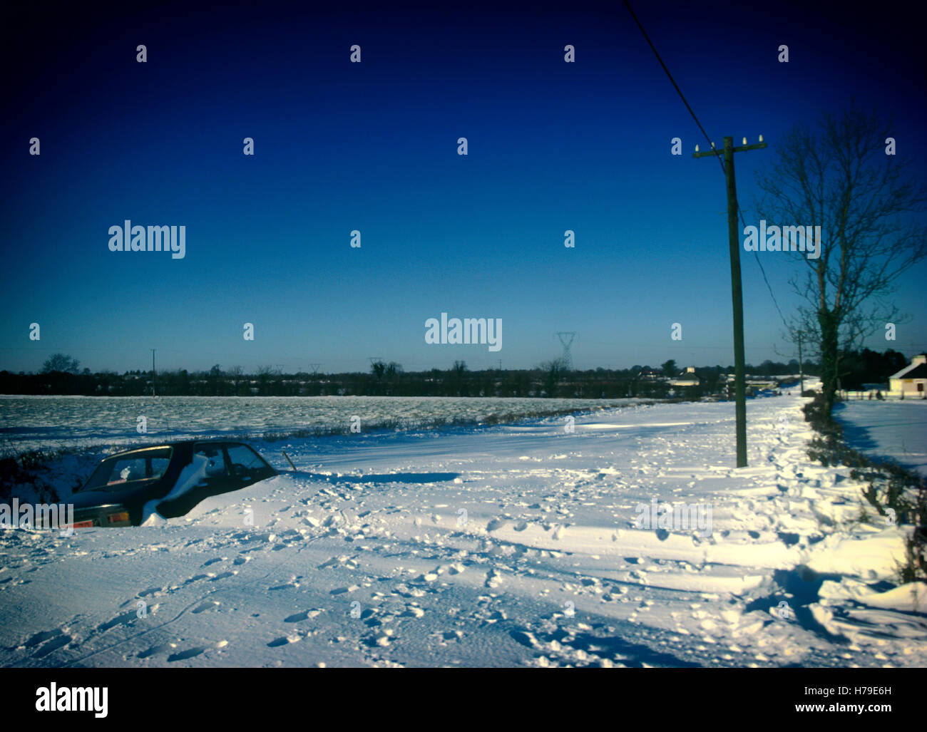 Auto abbandonate in una corsia bloccata da blizzard del 1982, in cui un forte vento da est lasciato i campi per lo più chiara e lasciato cadere la neve fino ad una altezza di 2 metri a nord - sud strade lasciando poi impassibile. Queste sono girato circa quattro miglia a nord di Ratoath, nella contea di Meath, Irlanda. Foto Stock