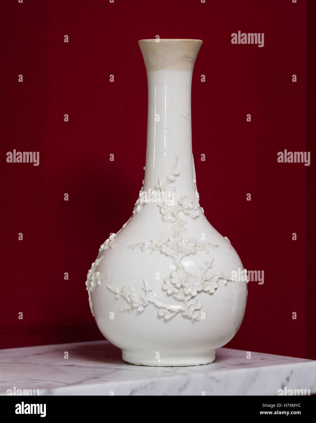 White Oriental Blossom vaso sulla da caminetto in marmo set contro il muro rosso nel palladiano del xviii secolo Dumfries house, Ayrshire, Scotl Foto Stock