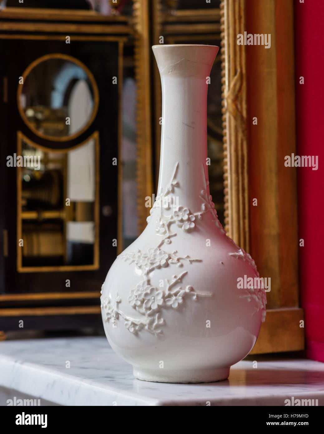 White Oriental Blossom vaso sulla da caminetto in marmo set contro il muro rosso nel palladiano del xviii secolo Dumfries house, Ayrshire, Foto Stock