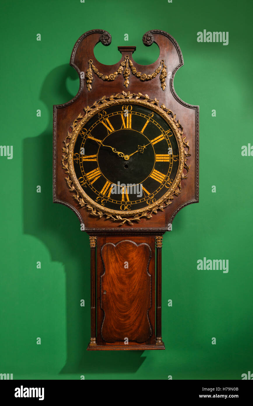 In legno antico orologio impostato sulla parete verde in Dumfries house, Ayrshire, in Scozia Foto Stock