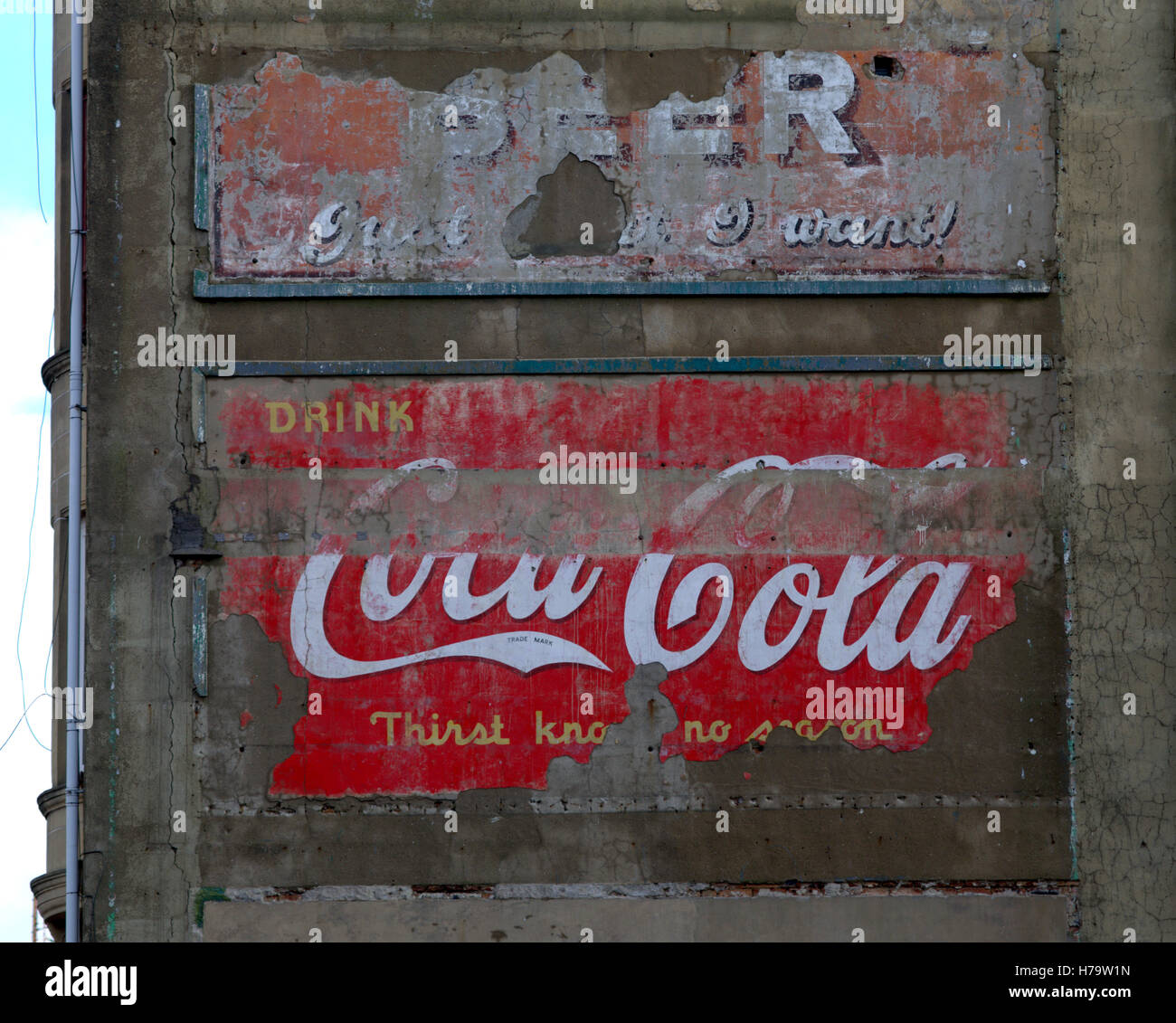 Vecchi segni pubblicitari vintage sul lato della costruzione di inquilini coke coca cola notizie del mondo e birra Foto Stock