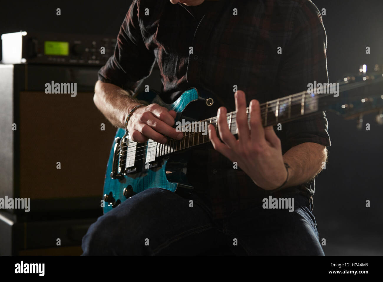 Close up uomo utilizzando la tecnica di maschiatura sulla chitarra elettrica Foto Stock