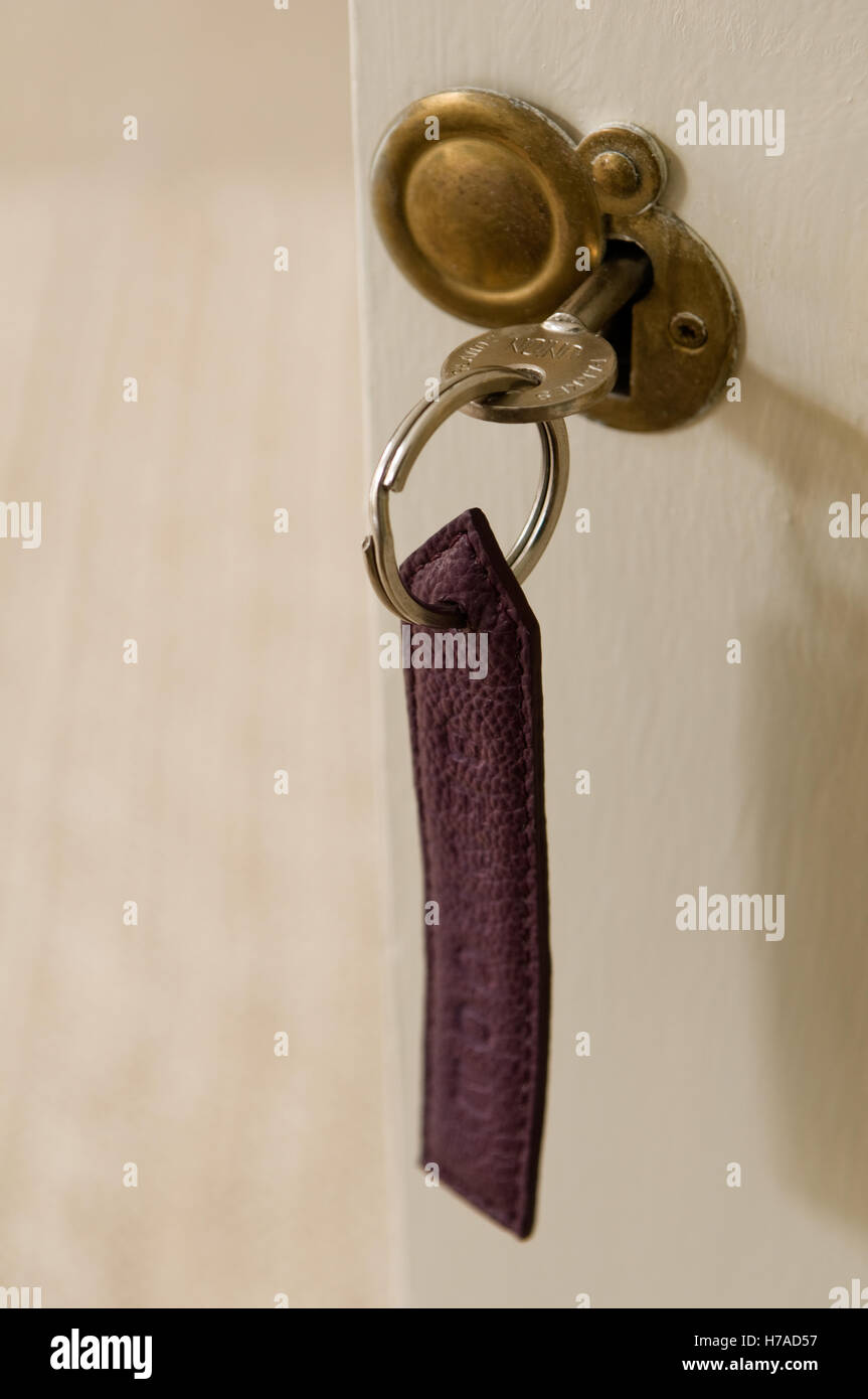 Viola portachiavi in pelle con la chiave nella serratura della porta Foto Stock