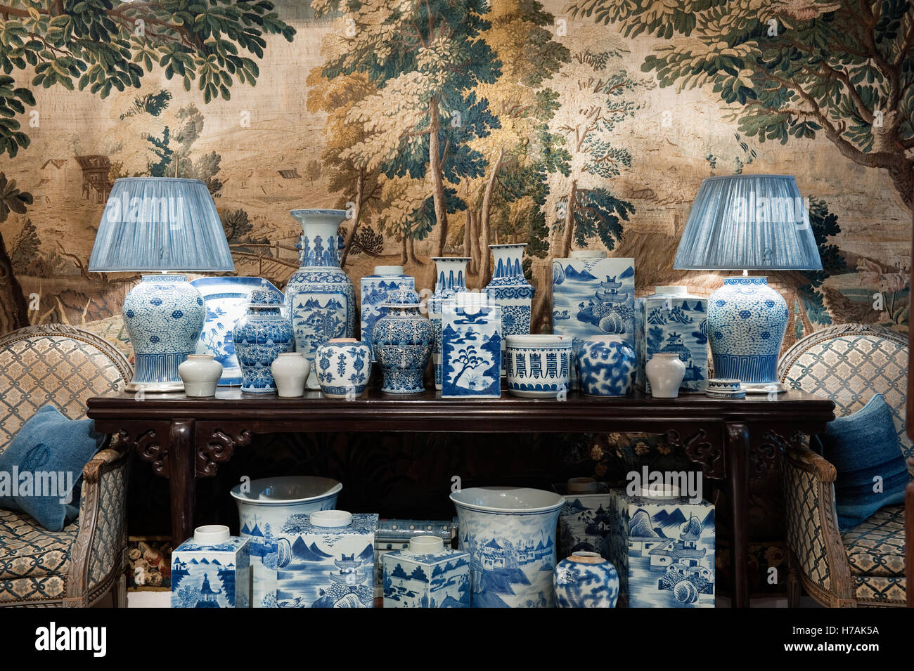 Una collezione di cinesi blu e bianca porcellana piantatrici e balaustra vasi sul tavolo console con tapestry discesa Guinevere Foto Stock