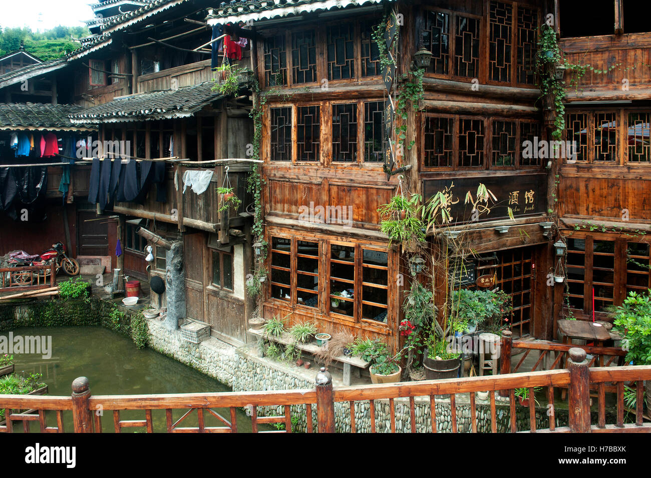 Le tipiche case di legno in montagna con balconi e finestre sopra il flusso di Zhaoxing, nella provincia di Guizhou, Cina Foto Stock