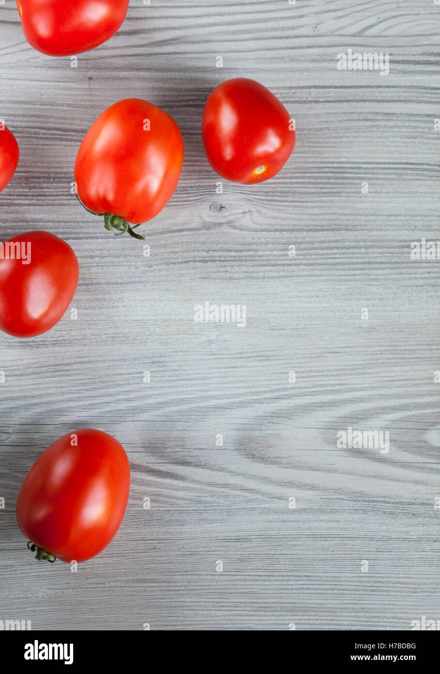 Rossi freschi pomodori in grigio sullo sfondo di legno con spazio di copia Foto Stock