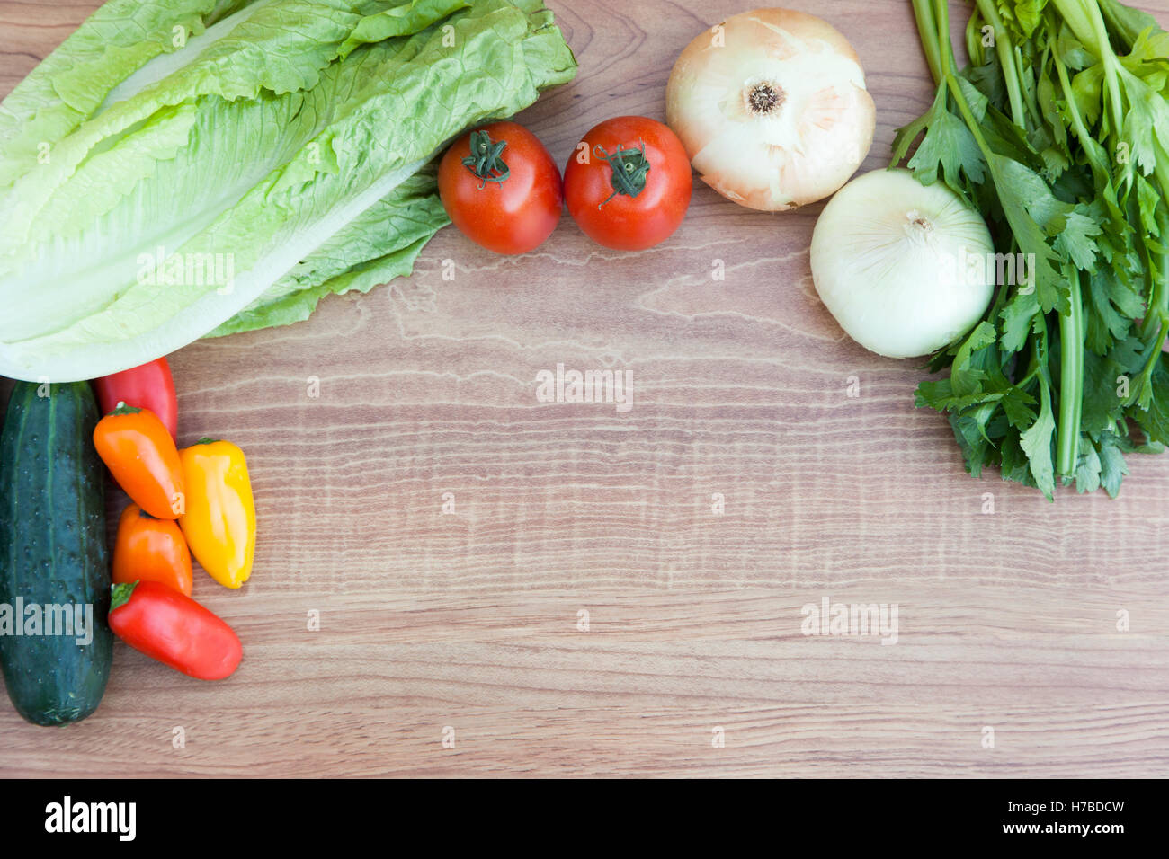 Ortaggi freschi (pomodori, peperoni, cipolle, cetrioli, lattuga e sedano) con il coltello sul taglio di legno cinghiale Foto Stock