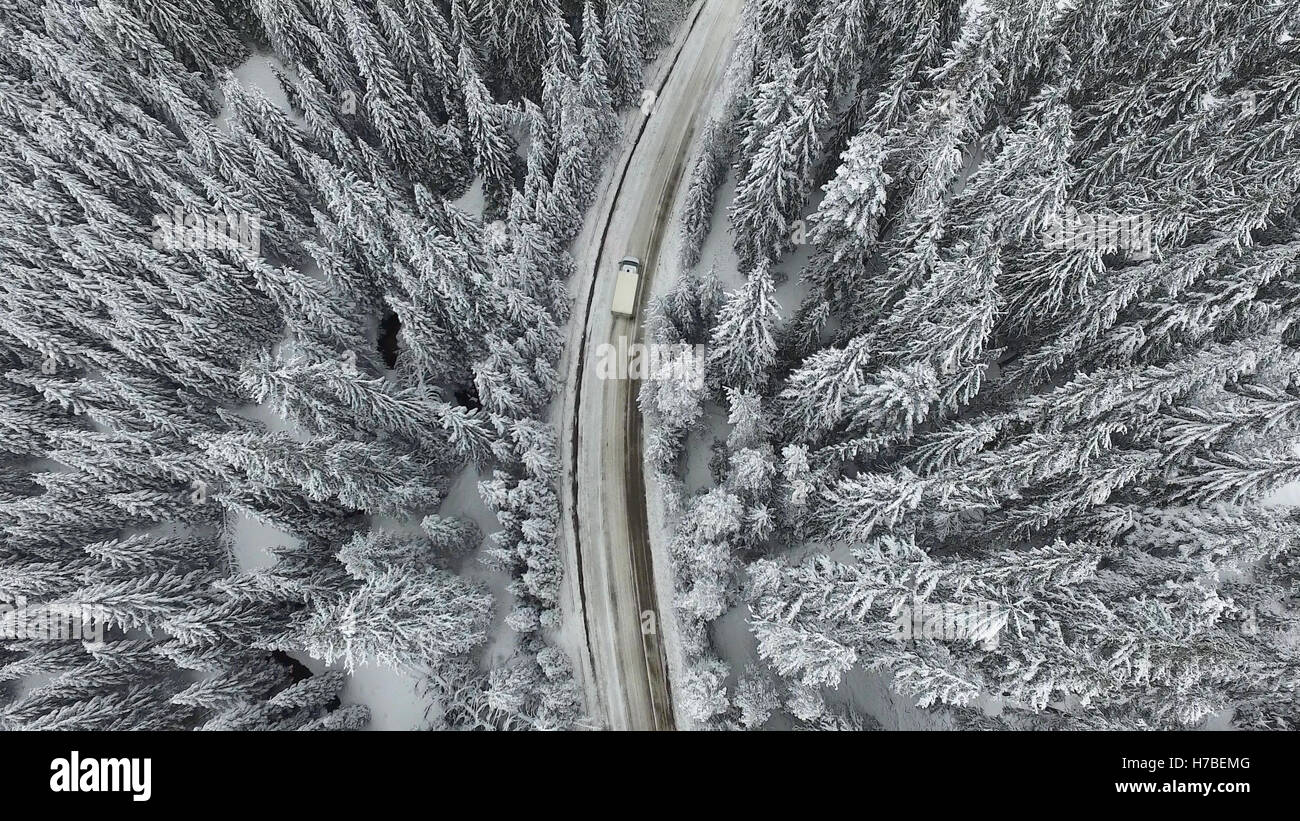 E nevoso inverno congelate di strada con una vettura in movimento su di esso. Foto Stock