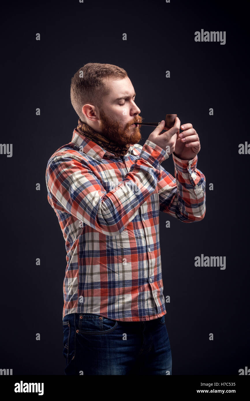 Elegante uomo barbuto tenuta tubo di fumo Foto Stock