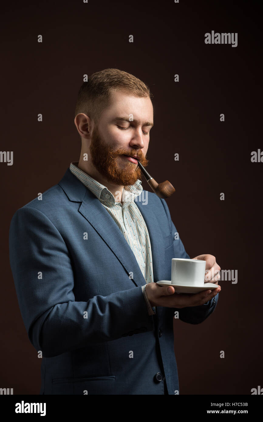 Ritratto di uomo in tuta tubo di fumo Foto Stock