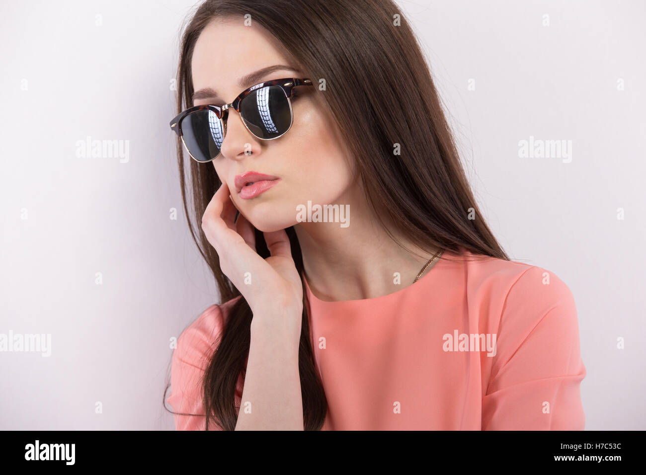 Bella giovane donna in occhiali da sole guardando la fotocamera Foto Stock