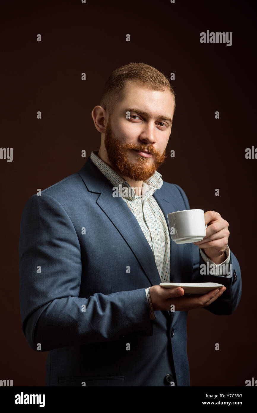 Elegante uomo barbuto con tazza di caffè Foto Stock