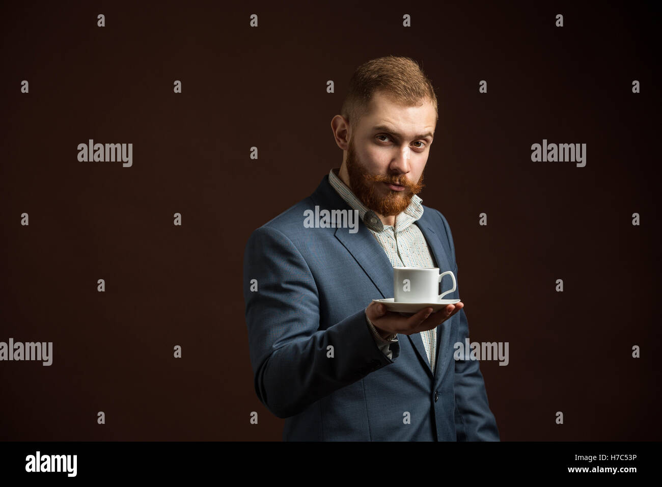 Elegante uomo barbuto con tazza di caffè Foto Stock