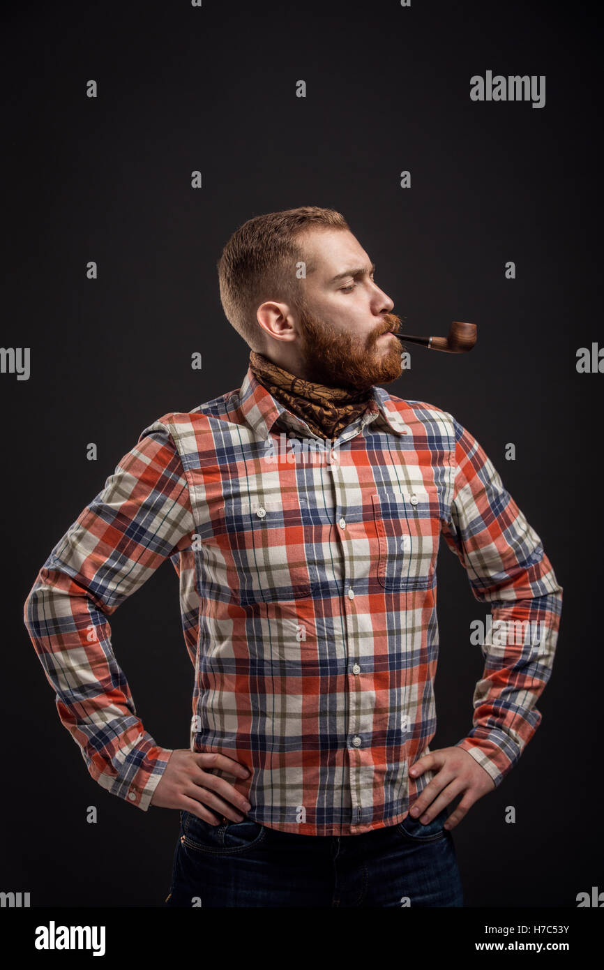 Elegante uomo barbuto tenuta tubo di fumo Foto Stock