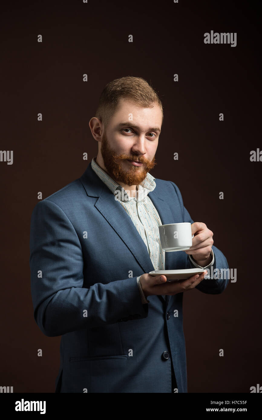 Elegante uomo barbuto con tazza di caffè Foto Stock