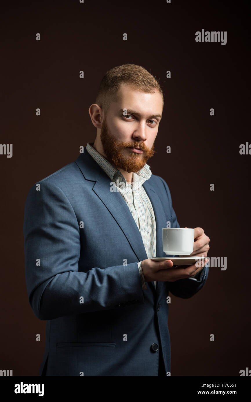 Elegante uomo barbuto con tazza di caffè Foto Stock