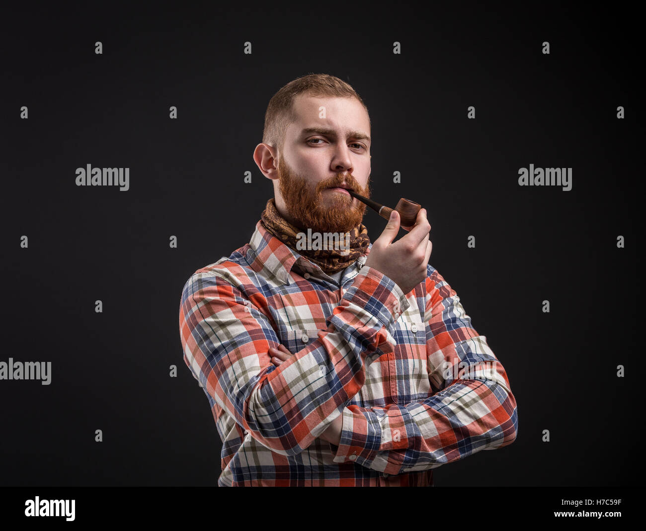 Elegante uomo barbuto tenuta tubo di fumo Foto Stock