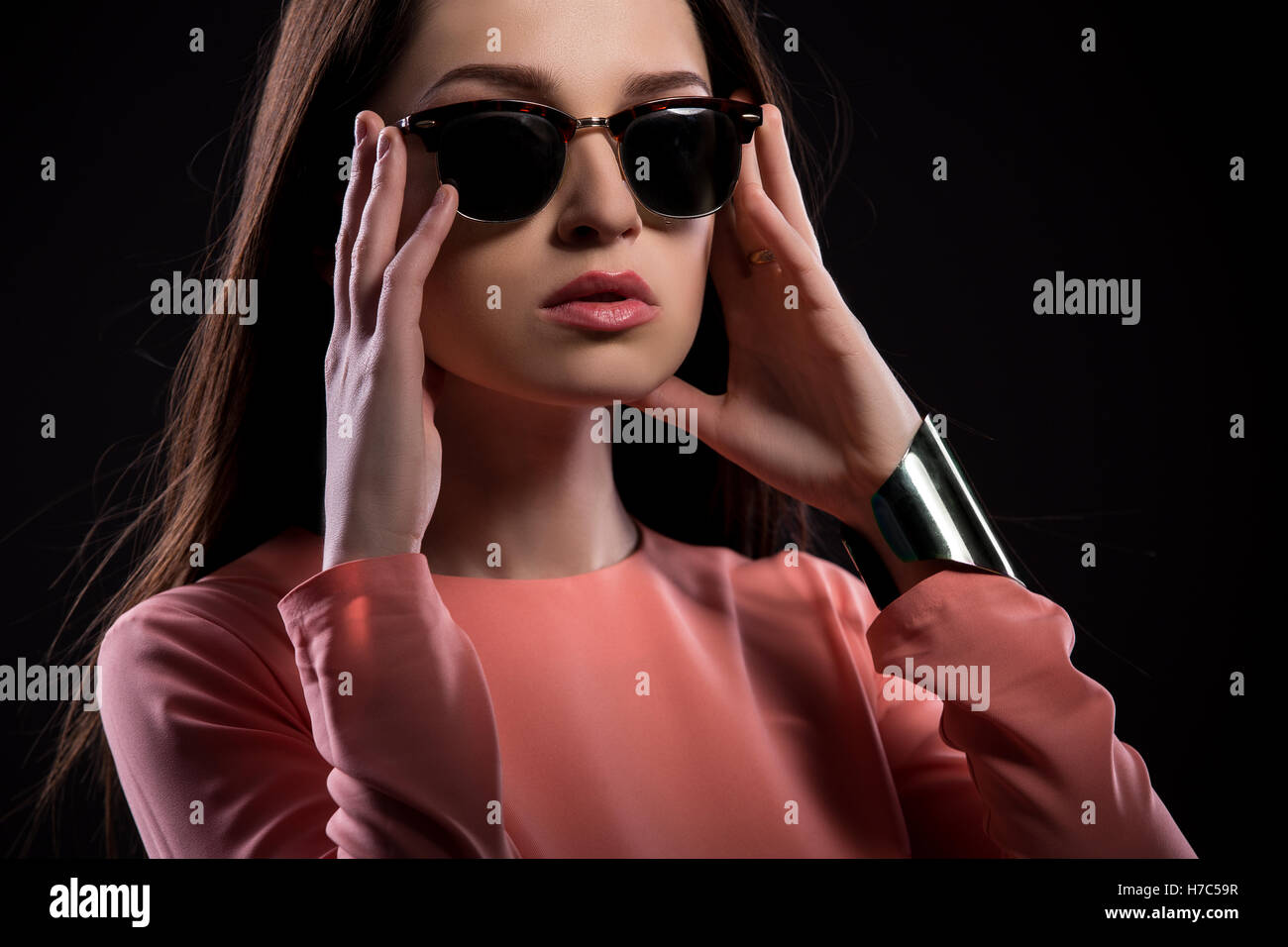 Bella giovane donna in occhiali da sole guardando la fotocamera Foto Stock