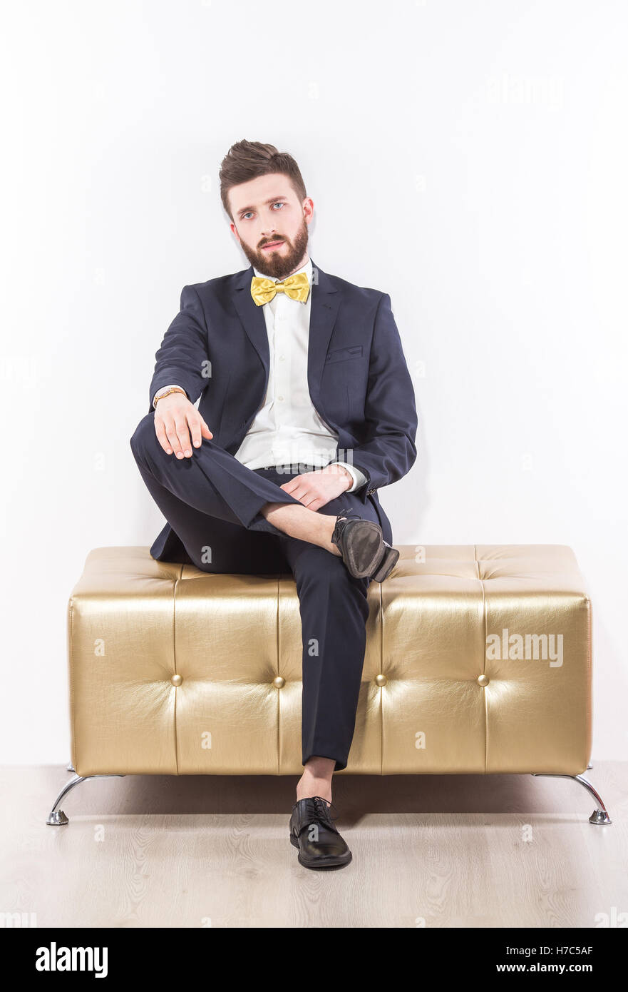 Elegante giovane uomo bello in nero abito classico con giallo bow tie-in Foto Stock