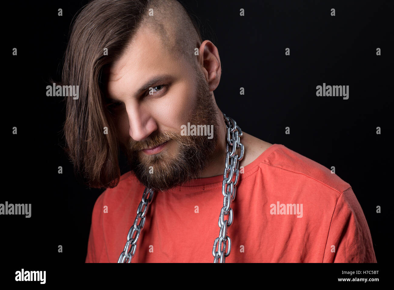 Ritratto di brutale uomo con rasato il tempio e la catena di metallo sul collo Foto Stock
