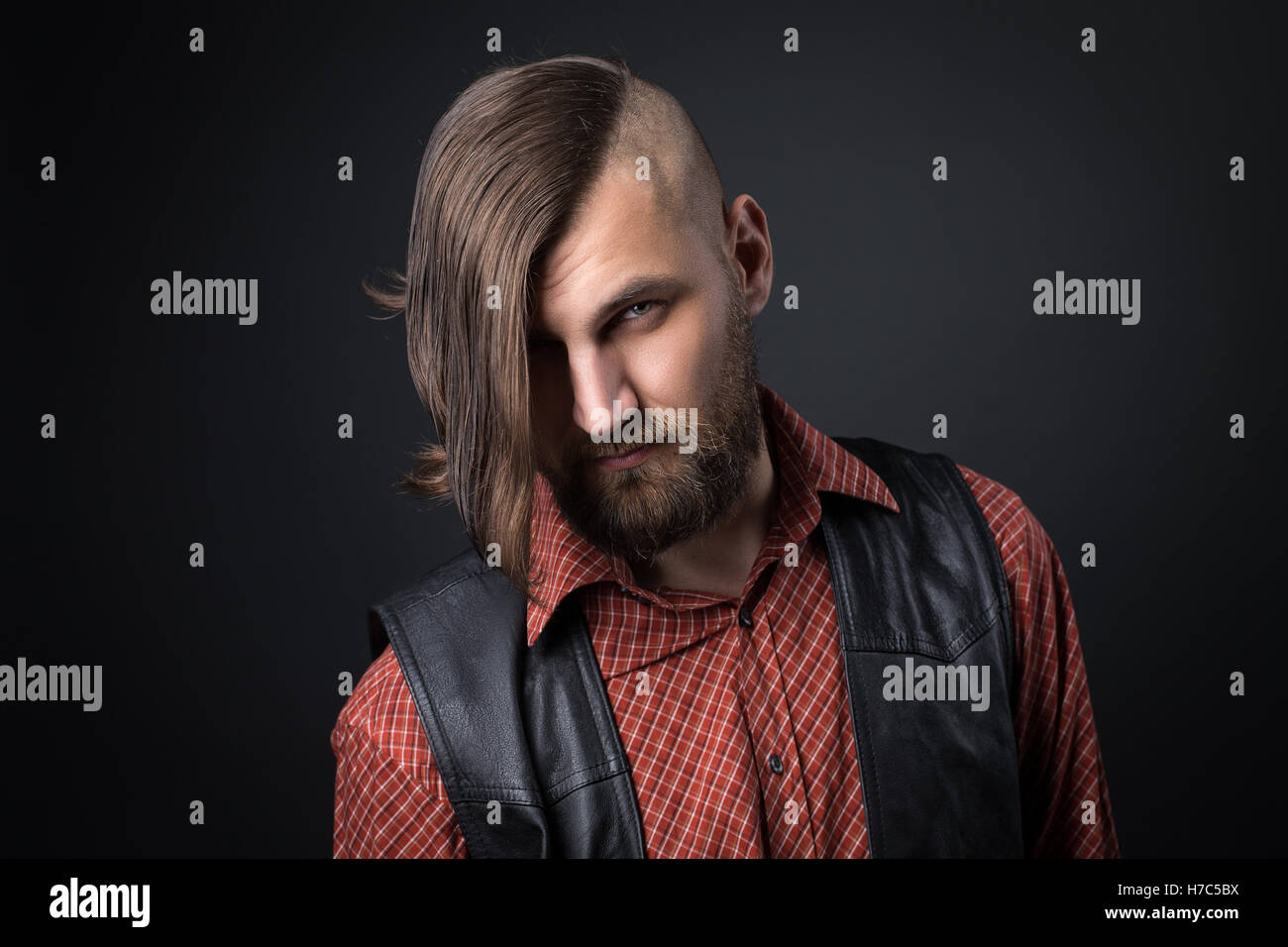 Uomo Barbuto in panciotto guardando la telecamera Foto Stock