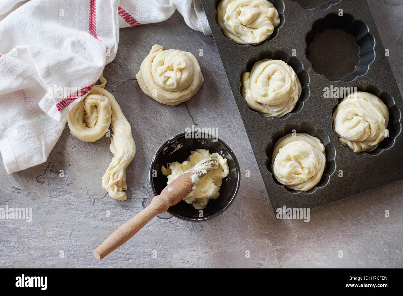 Preparare la pasticceria moderna cruffins interi e slice, come croissant e muffin. Pasta di turbolenza nel silicio forma di cottura con coppa di bu Foto Stock