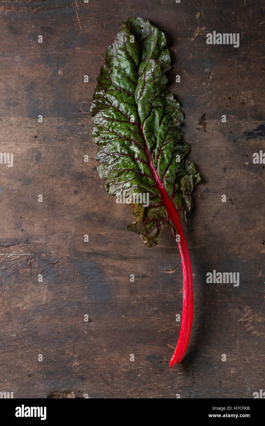 Bietole novelle mangold foglie di insalata su un vecchio legno scuro dello sfondo. Vista da sopra con spazio per il testo. Mangiare sano tema. Foto Stock