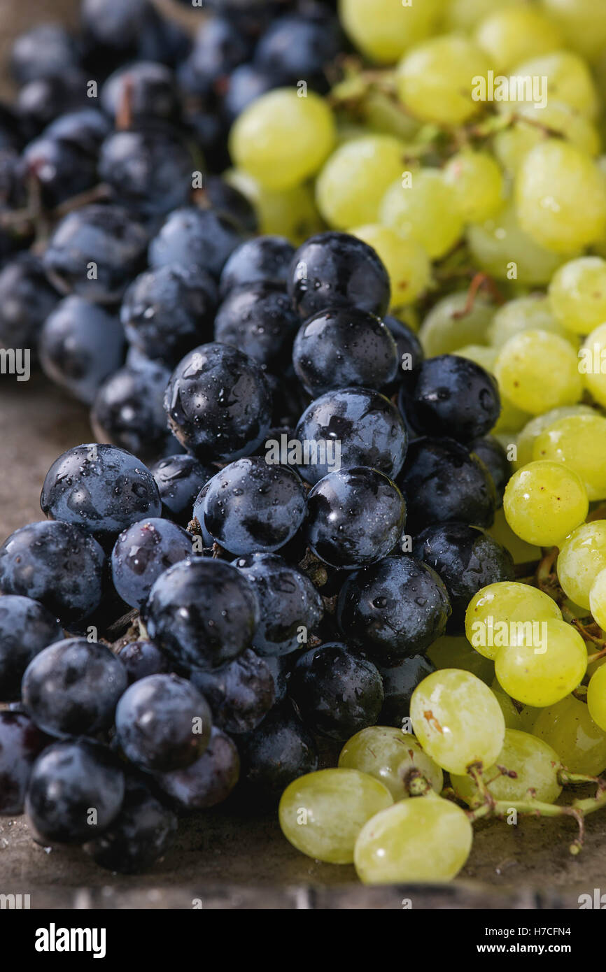 I grappoli di ripe rosso bagnato e uve bianche su vecchie texture di sfondo di metallo. Close up Foto Stock